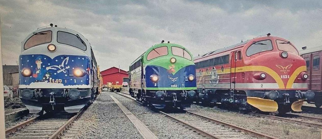 Drei farbenfrohe Lokomotiven im Depot